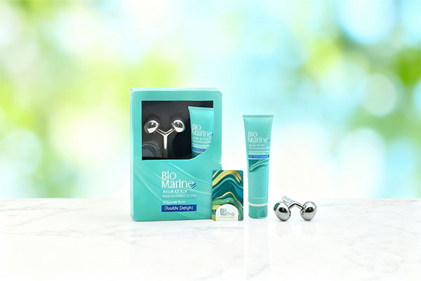 کرم ماساژ همراه ماساژور آکوا دتوکس بایومارین روی سطح مرمر سفید