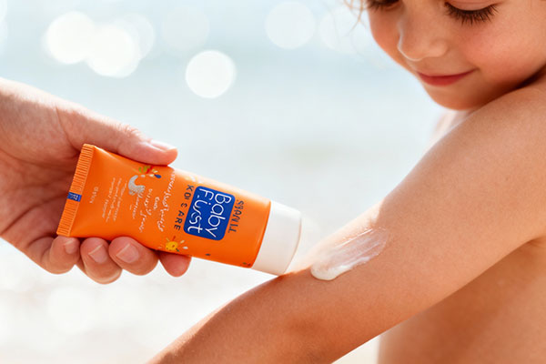 کودک در حال استفاده از کرم ضد آفتاب کودکان بیبی فرست SPF30 در فضای باز