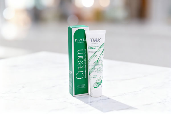 تصویر کرم مرطوب کننده دست و ناخن ناک روی سطح مرمر سفید