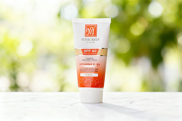 تصویر کرم ضد آفتاب رنگی پوست خشک مای SPF60 روی سطح مرمر سفید