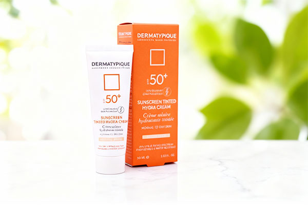 تصویر کرم ضد آفتاب پوست خشک درماتیپیک SPF50 روی سطح مرمر سفید