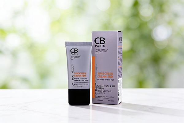تصویر کرم ضد آفتاب پوست خشک سی بی پاریس SPF50 روی سطح مرمر سفید