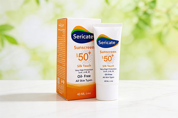 تصویر کرم ضد آفتاب سیلک تاچ SPF50 سری کیت روی سطح مرمر سفید