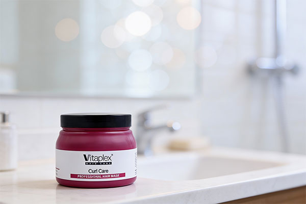 ماسک ترمیم کننده موهای فر ویتاپلکس روی میز حمام