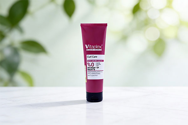 اسپری نرم کننده موهای فر ویتاپلکس در کنار برگ&zwnj;های سبز و قطرات آب