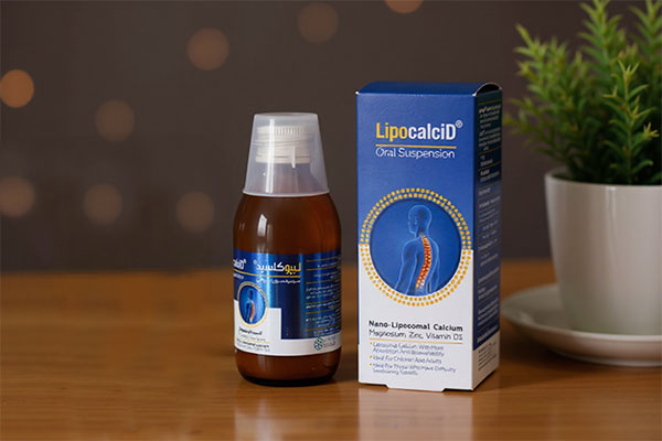 شربت لیپوکلسید کیمازی کنار لیوان آب و گیاه