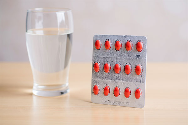 تصویر قرص یونی فرو کنار لیوان آب