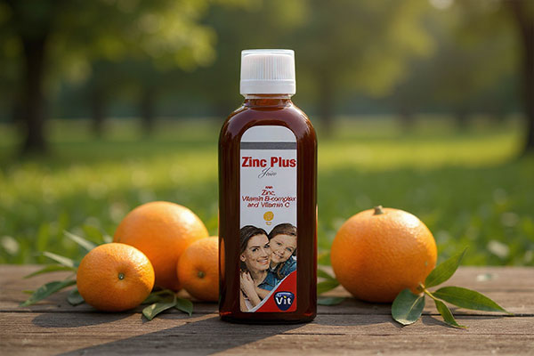 شربت زینک پلاس استار ویت در کنار پرتقال و برگ‌های سبز