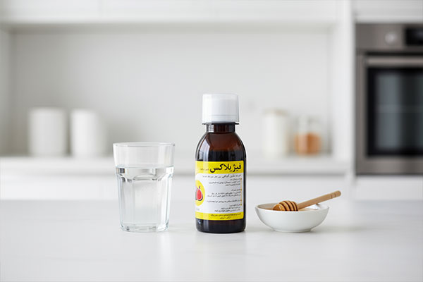 شربت فیژیلاکس نیاک در آشپزخانه با عسل و آب
