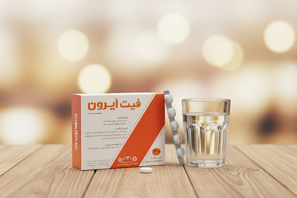 قرص فیت آیرون نیاک کنار لیوان آب