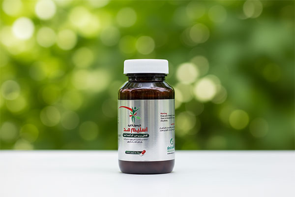 کپسول اسلیم مد اکسیر گستر اسپادانا روی سطح سفید با پس‌زمینه طبیعی