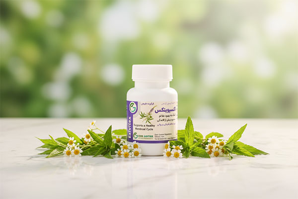 کپسول اکسیویتکس اکسیر گستر اسپادانا روی سطح سفید با برگ‌های سبز