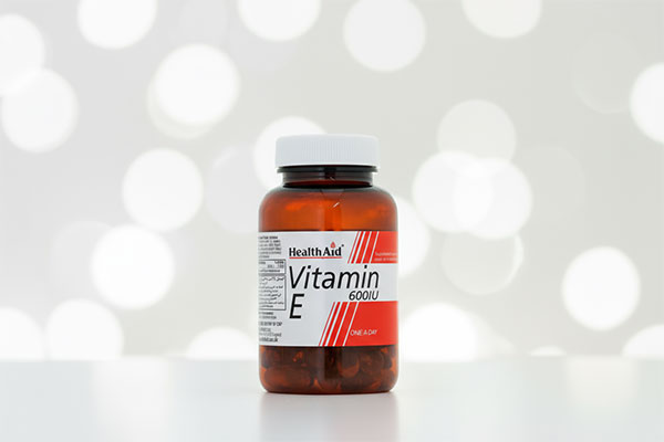 کپسول ویتامین ای 600 هلث اید روی سطح سفید