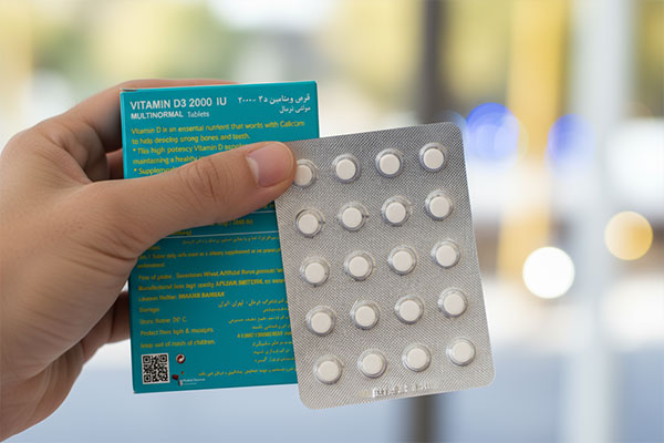 قرص ویتامین D3 2000 مولتی نرمال در دست برای نمایش جزئیات بسته‌بندی