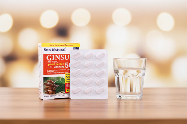 قرص جینسان سان نچرال کنار لیوان آب