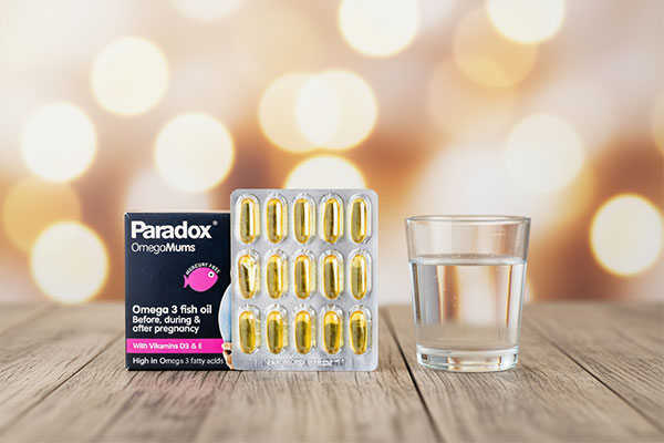 کپسول امگا مادران پارادوکس کنار لیوان آب