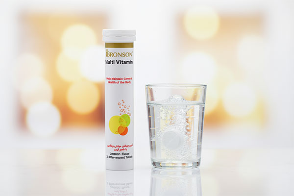 قرص جوشان مولتی ویتامین برونسون در کنار لیوان آب