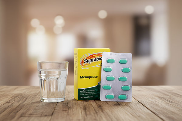 قرص منوپوز سوپرابیون کنار لیوان آب