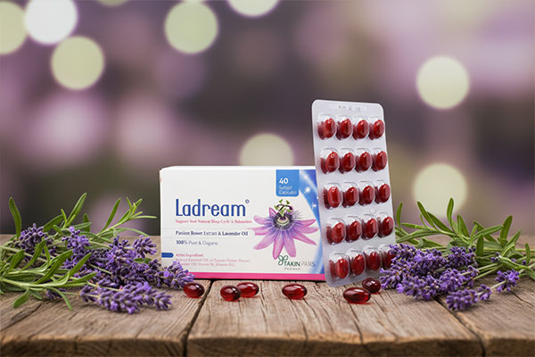 کپسول لادریم همراه با گلهای اسطوخودوس روی میز چوبی