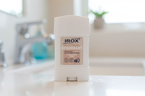 دئودرانت استیک کرمی وایت کلد ایروکس روی پیشخوان حمام سفید