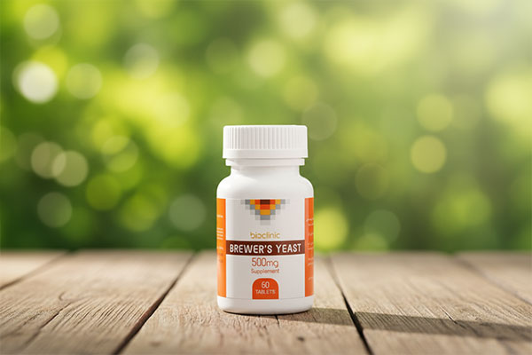 قرص مخمر آبجو بایوکلینیک روی میز چوبی