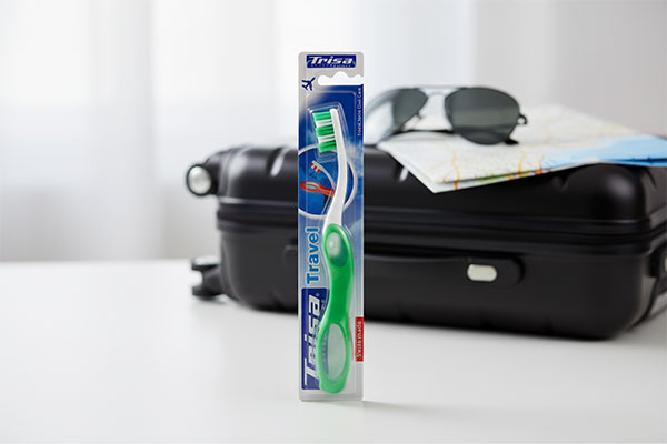 مسواک تراول تاشو متوسط تریزا در کنار وسایل سفر