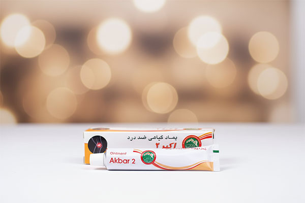 پماد اکبر 2 ضد درد حکیم مومن تبریزی روی سطح سفید