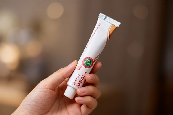 پماد اکبر 2 ضد درد در دست برای نمایش بسته‌بندی