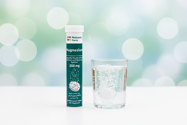 قرص جوشان منیزیم 250 نیچرز پلنتی در کنار لیوان آب