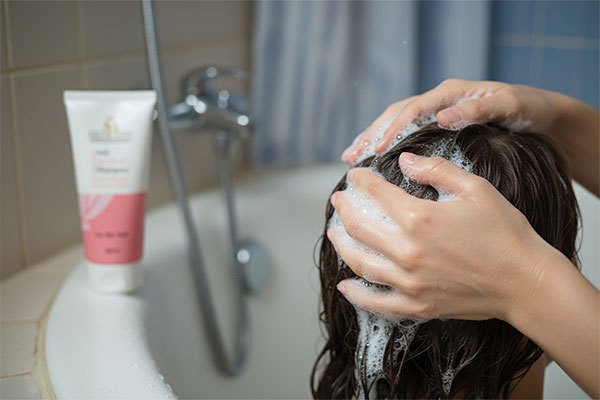 شامپو ضد شوره موهای خشک مدیلن روی پیشخوان حمام