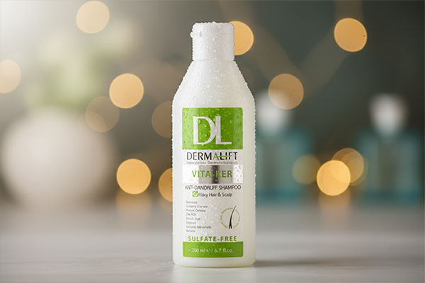 نمای نزدیک شامپو ضد شوره موهای چرب ویتاکر درمالیفت با قطرات آب