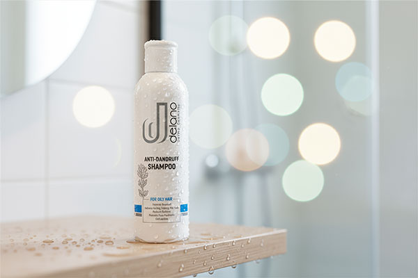 بطری شامپو ضد شوره موهای چرب دلانو در محیط حمام