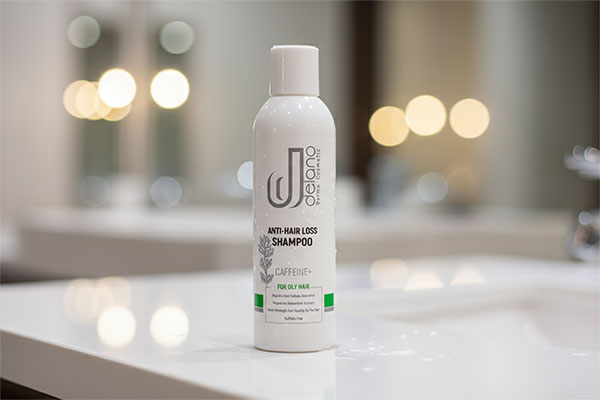 شامپو ضد ریزش موهای چرب کافئین دلانو روی میز حمام