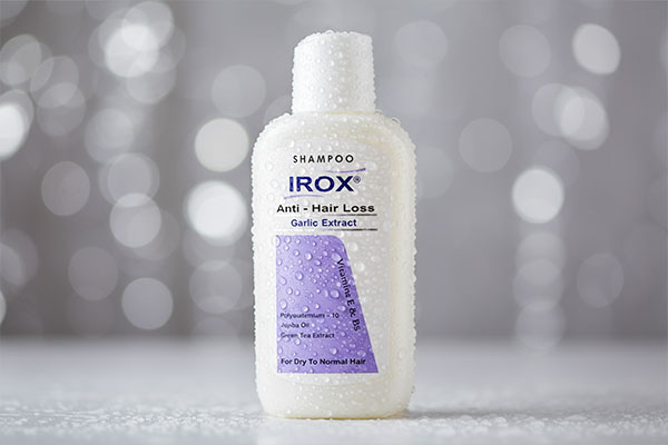 نمای نزدیک شامپو تقویت‌کننده سیر ایروکس با قطرات آب