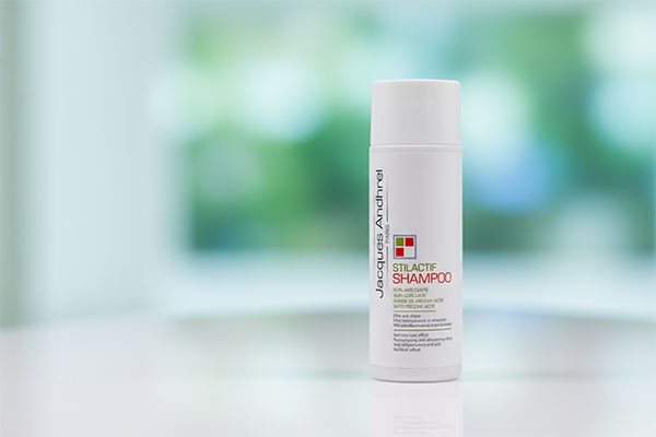 شامپو موهای چرب استیل اکتیو ژاک آندرل روی پیشخوان حمام