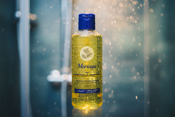 نمای نزدیک شامپو مورینگا برای موهای چرب با قطرات آب