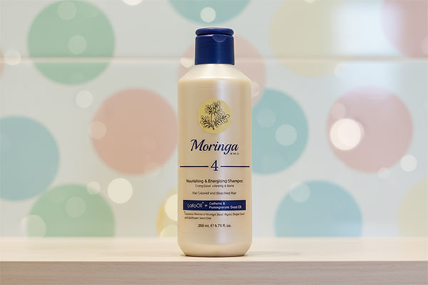 شامپو مغذی موهای رنگ شده و دکلره ۴ مورینگا روی قفسه حمام