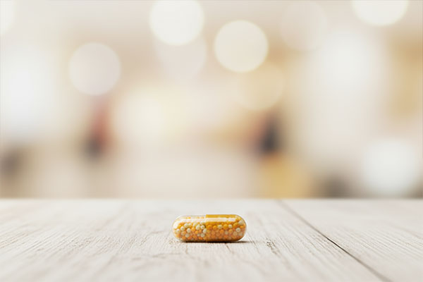 یک کپسول ویتامین سی و زینک استار ویت روی میز چوبی