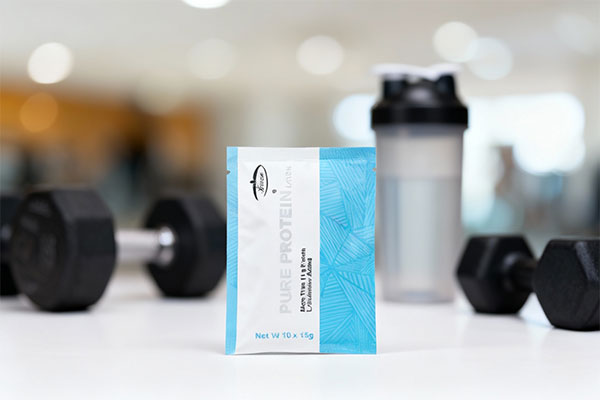 ساشه پودر پیور پروتئین کارن در کنار تجهیزات ورزشی