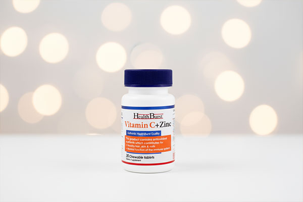 قرص جویدنی ویتامین سی و زینک هلث برست روی سطح سفید