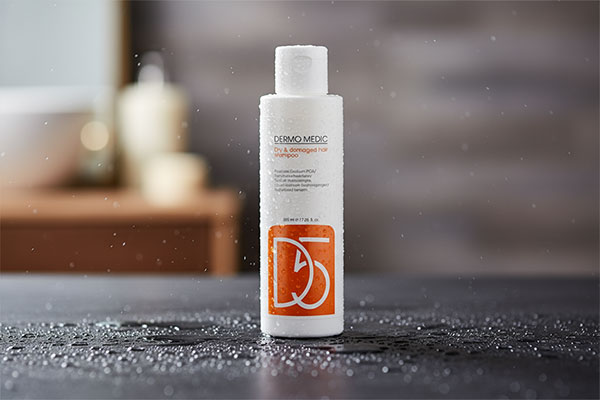 نمای نزدیک شامپو کنترل چربی سر درمومدیک با قطرات آب