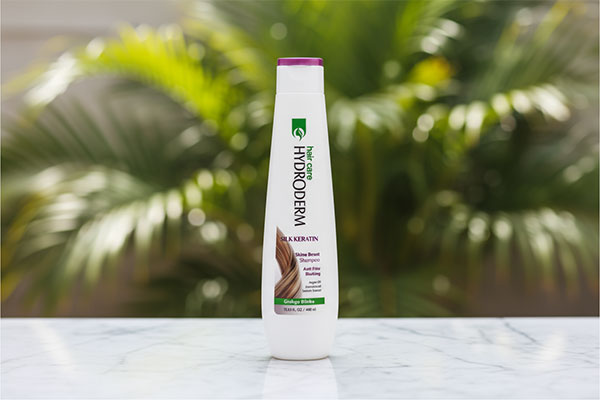 شامپو براق کننده موهای وزدار ابریشم و کراتین هیدرودرم روی سطح مرمر