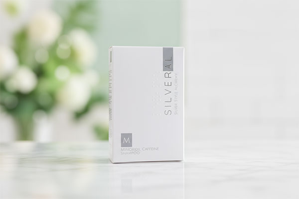 شامپو ماینوکسیدیل کافئین سیلورال روی پیشخوان حمام