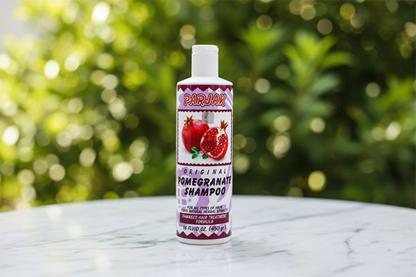 شامپو انار پرژک روی سطح مرمری سفید