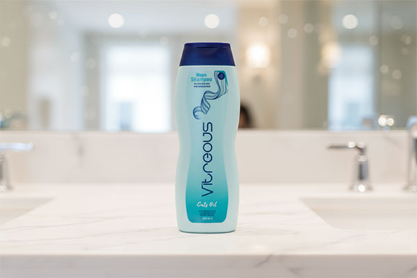 بطری شامپو موهای چرب ویتروس روی پیشخوان حمام