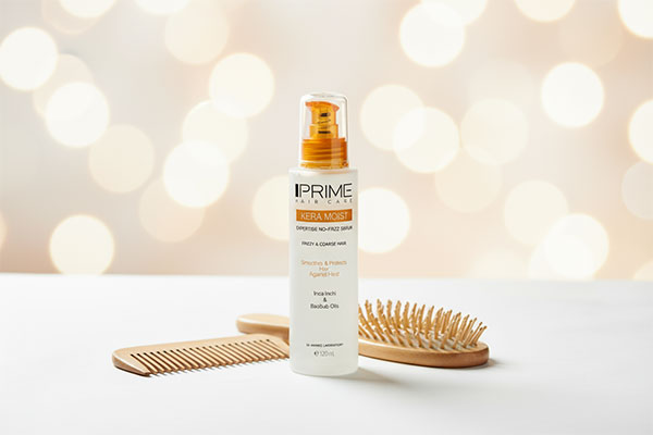 سرم نرم کننده موهای وزدار پریم روی سطح سفید با لوازم مراقبت مو