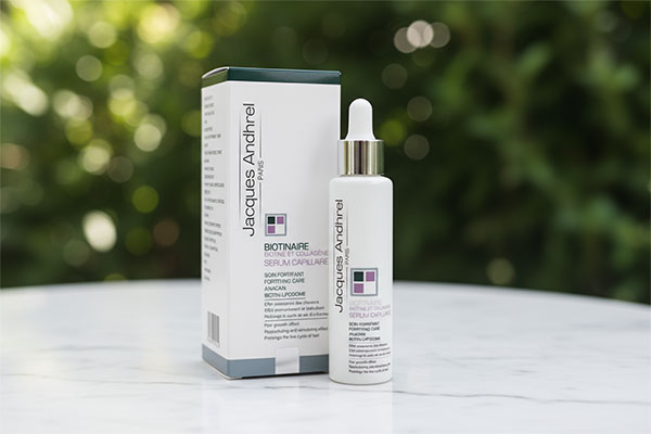 سرم تقویت کننده مو بیوتین و کلاژن ژاک آندرل روی سطح مرمر سفید