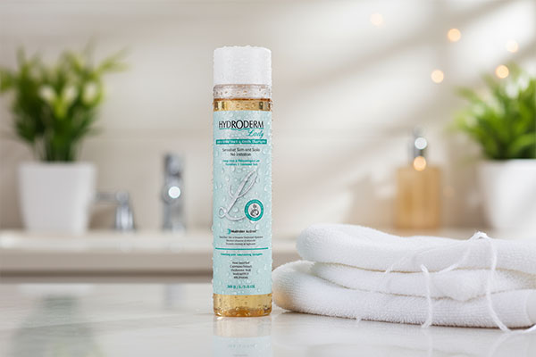 شامپو ملایم سر و بدن هیدرودرم کنار حوله سفید