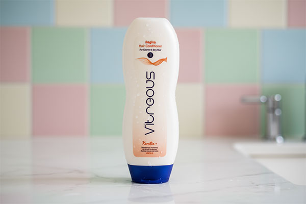 نرم کننده موهای رنگ شده و خشک رجینا ویتروس روی پیشخوان حمام