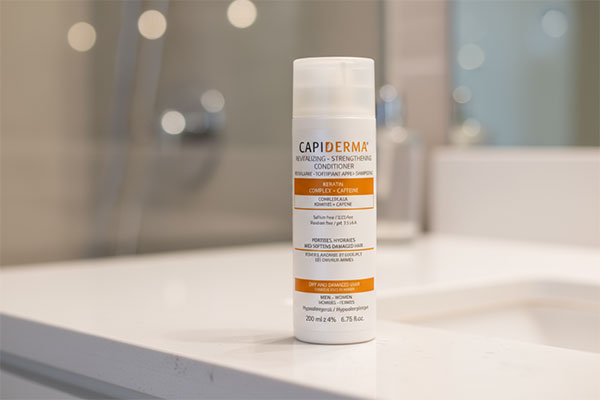 نرم کننده موی کراتین و کافئین کپیدرما روی میز سفید